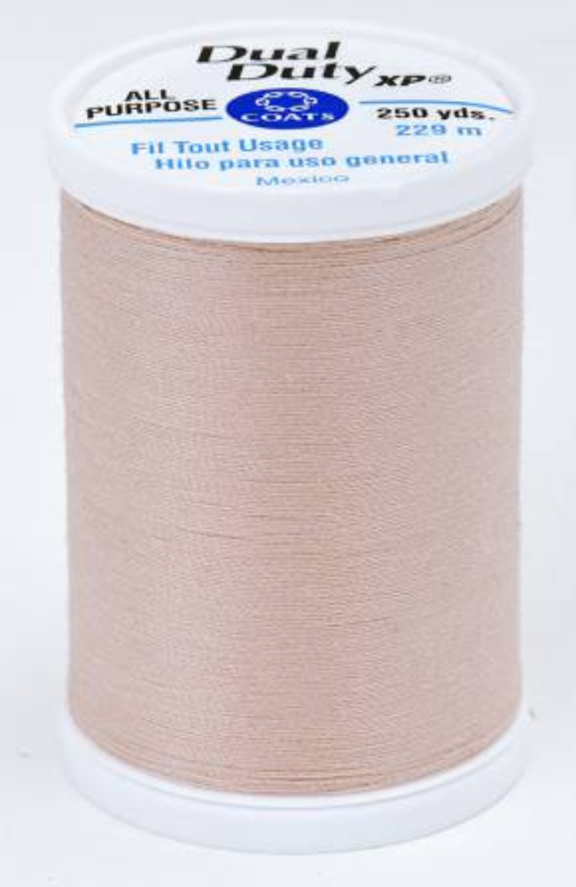 A spool of light beige Dual Duty XP sewing thread with a white label featuring blue and black text, set against a plain white background.