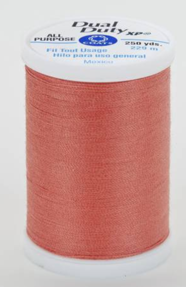 A spool of orange Dual Duty XP sewing thread with a white label featuring blue and black text, set against a plain white background.