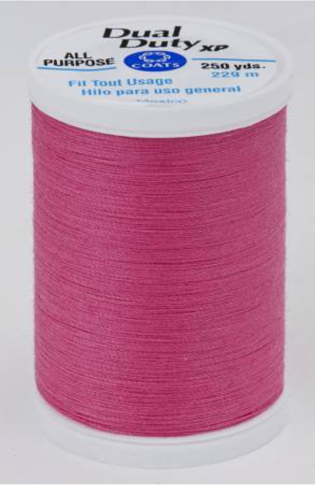 A spool of dark pink Dual Duty XP sewing thread with a white label featuring blue and black text, set against a plain white background.