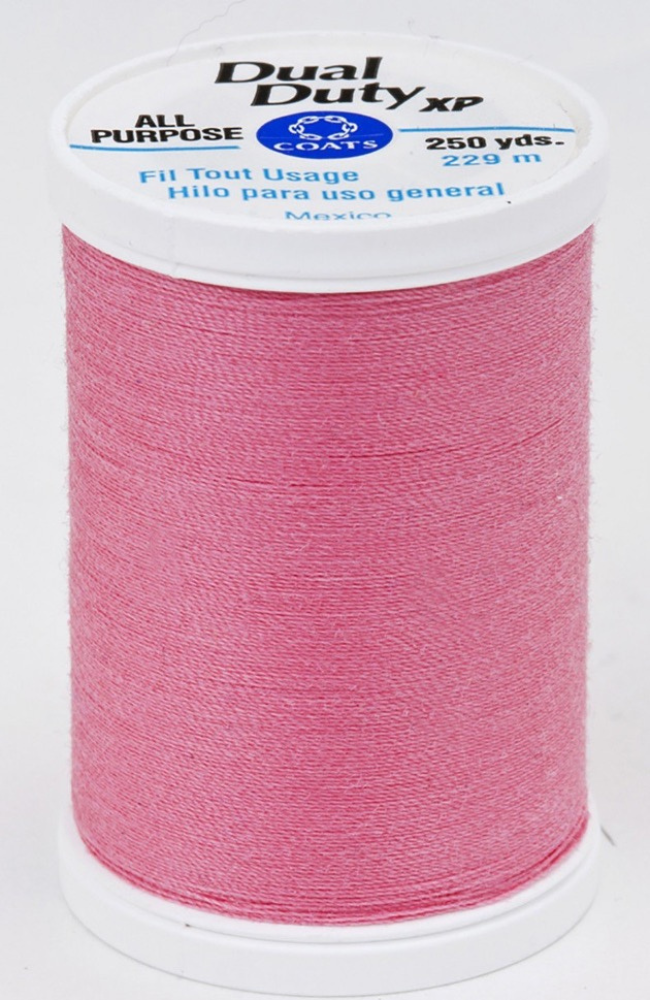 A spool of dark pink Dual Duty XP sewing thread with a white label featuring blue and black text, set against a plain white background.