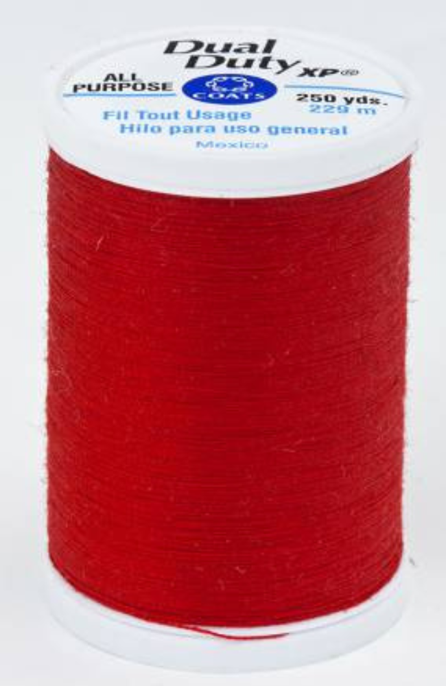A spool of red Dual Duty XP sewing thread with a white label featuring blue and black text, set against a plain white background.