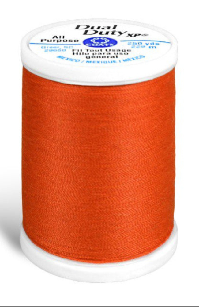 A spool of orange Dual Duty XP sewing thread with a white label featuring blue and black text, set against a plain white background.