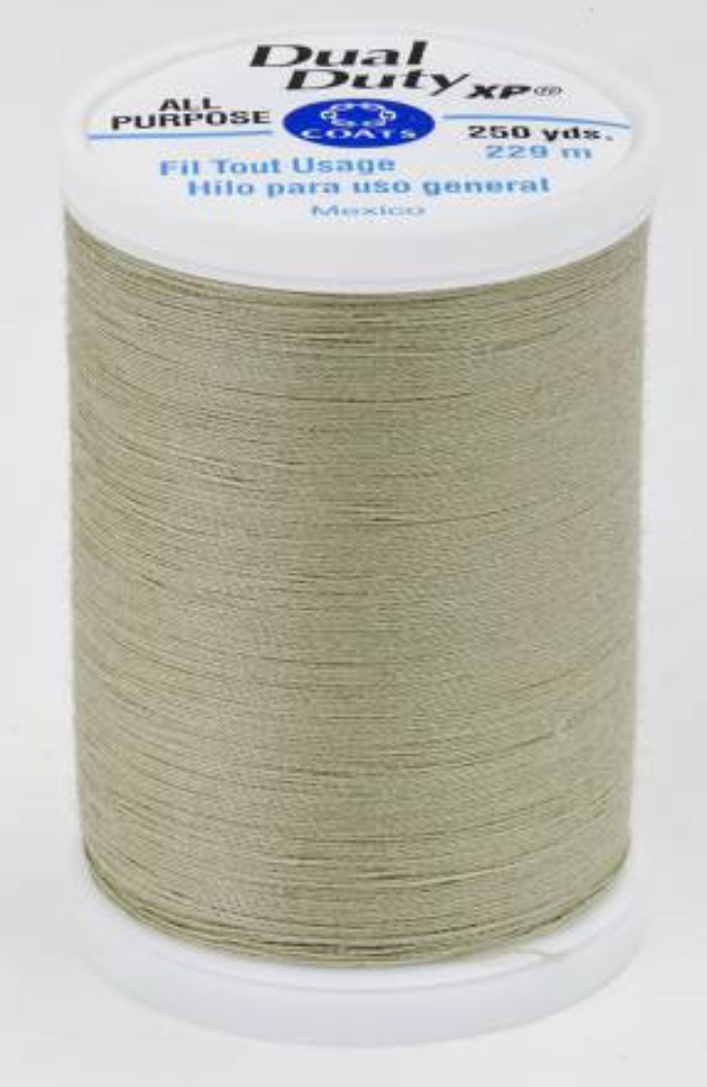 A spool of light green Dual Duty XP sewing thread with a white label featuring blue and black text, set against a plain white background.