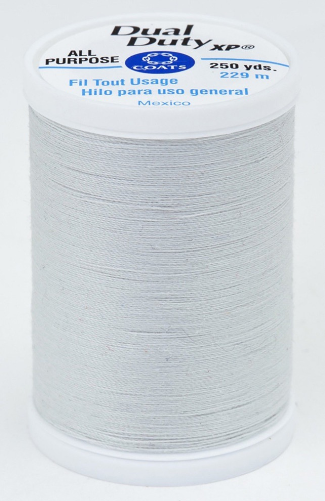 A spool of light gray Dual Duty XP sewing thread with a white label featuring blue and black text, set against a plain white background.
