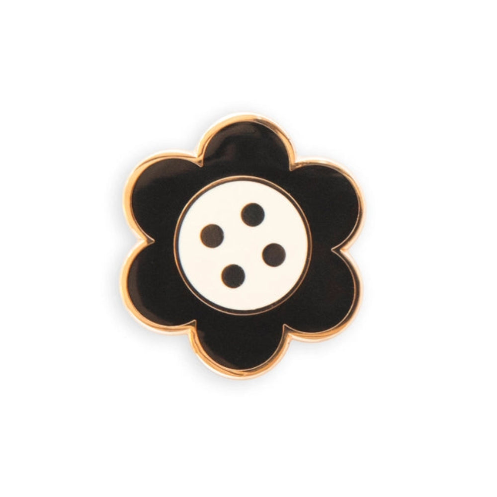 A black and white daisy button needle minder on a white background