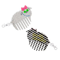 White poodle-shaped comb charm and the flipside that's striped with the brand name written on it