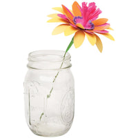 Clear glass mason jar with a colorful artificial flower on a white background