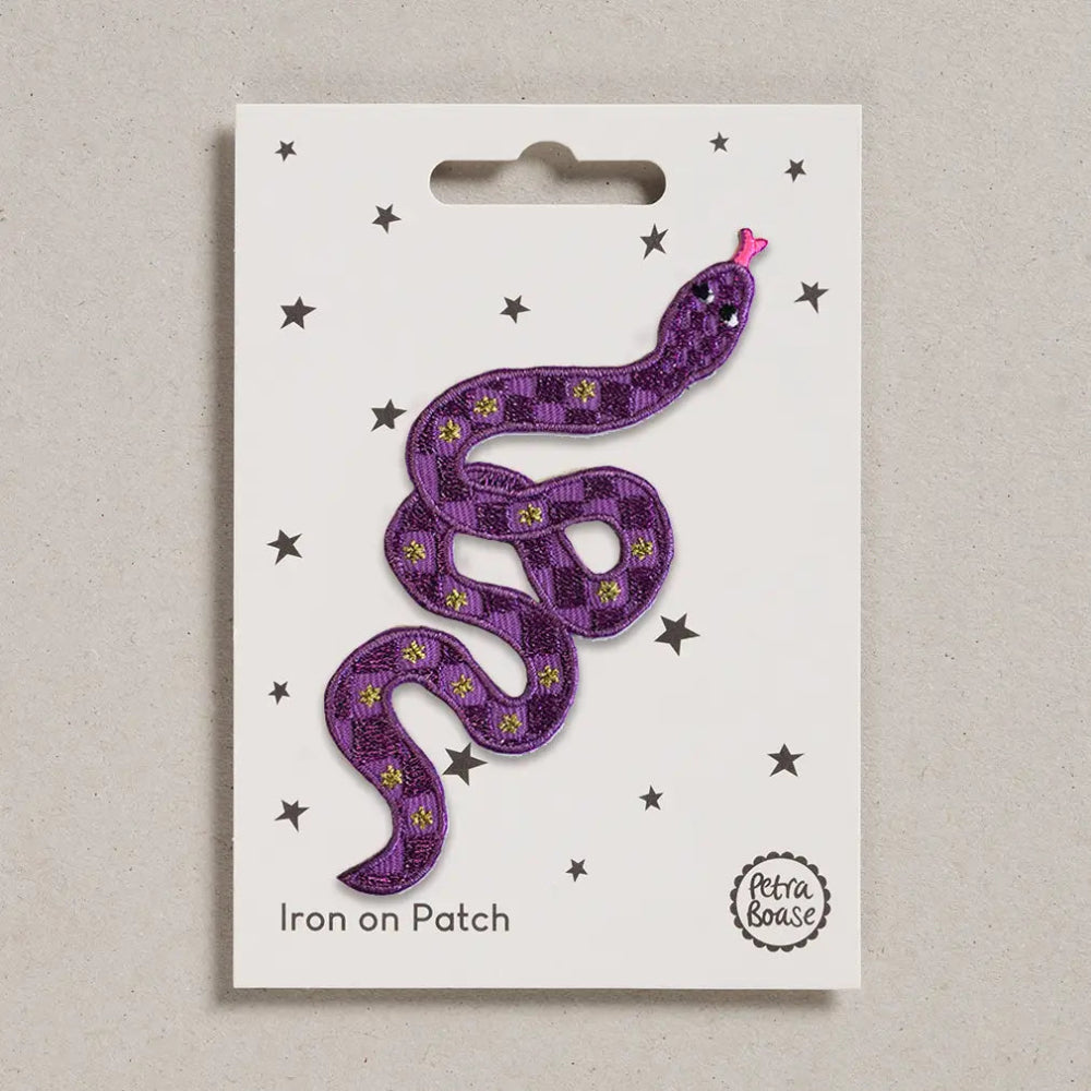 Purple snake-shaped iron on patch on a white card with star decorations, brand 'Lotta Louse' visible.