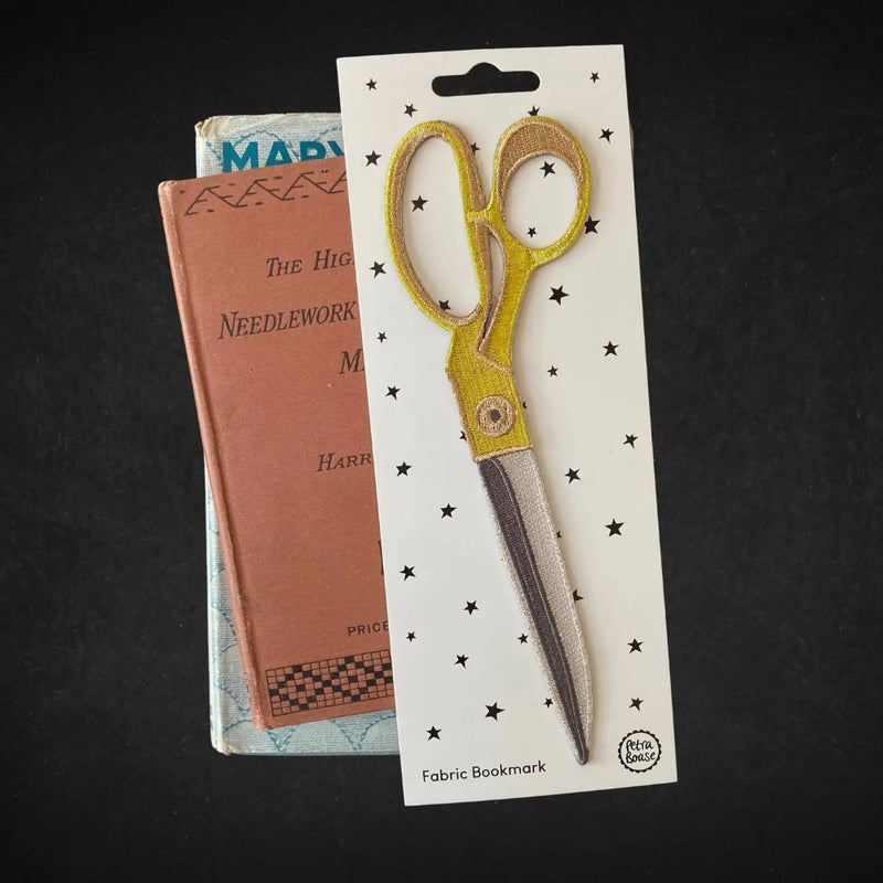 Fabric bookmark shaped like a pair of scissors on a black background