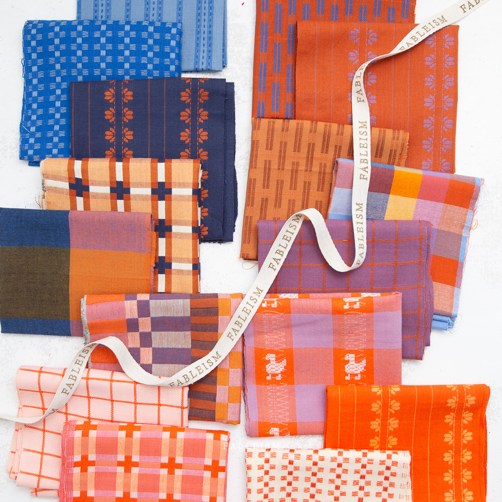 Collection of patterned fabric swatches in various colors with a visible brand name, "Fableism".