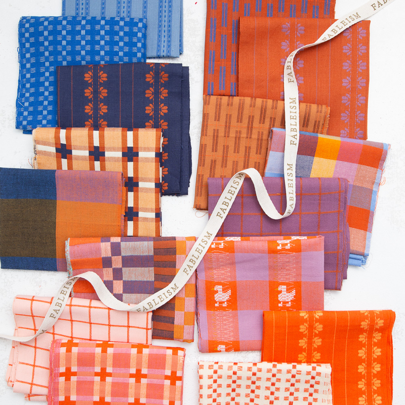 Collection of patterned fabric swatches in various colors with a visible brand name, "Fableism".