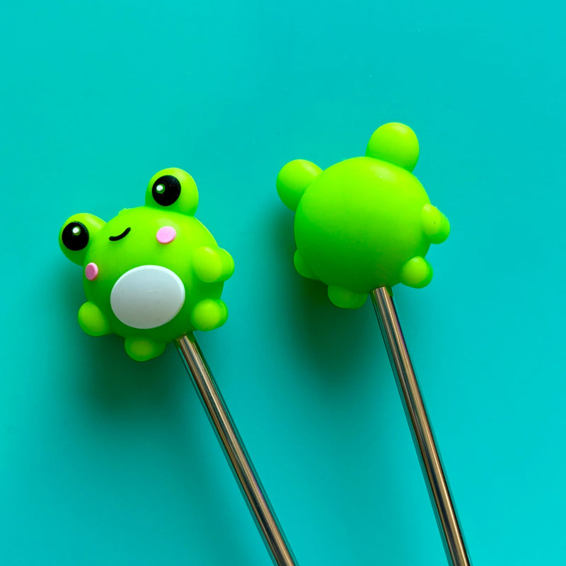 Two green frog silicone ends on needles on a turquoise background.