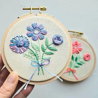 Embroidery hoops with floral designs against a light gray background