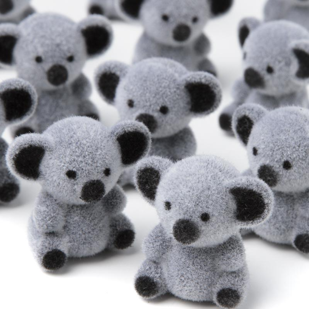 Small fuzzy gray koala miniatures on a white background.