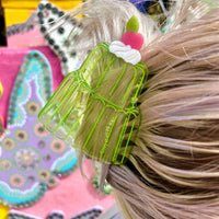 Clear green acetate hair claw in the shape of a jello mold, clipped into blonde hair.