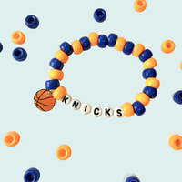 Beaded bracelet with 'Knicks' charm on a light blue background