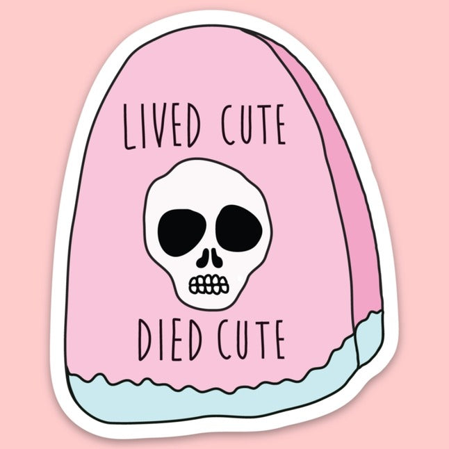 Pink tombstone with a skull and blue border on bottom with the words "Lived cute, died cute".