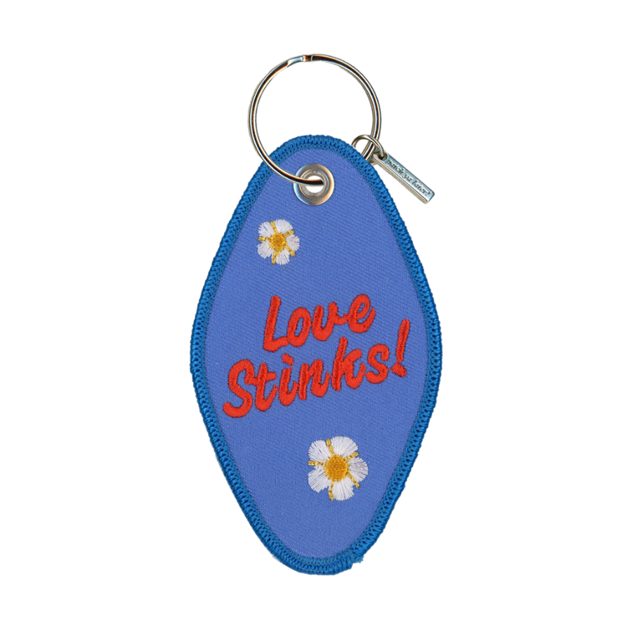 Blue embroidered motel-style keychain that reads "love stinks!"