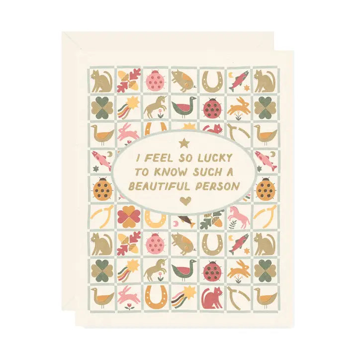 Beige greeting card featuring a vintage inspired quilt illustration with text that reads “I feel lucky to know such a beautiful person" on a white background.