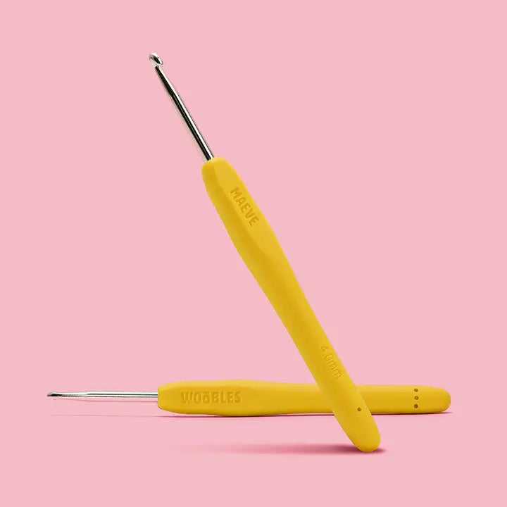 yellow crochet hook on a pink background