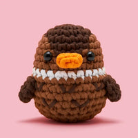 Crocheted duck in shades of brown on a pink background