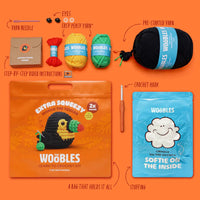 Crochet kit with yarn, hook, and packaging on an orange background