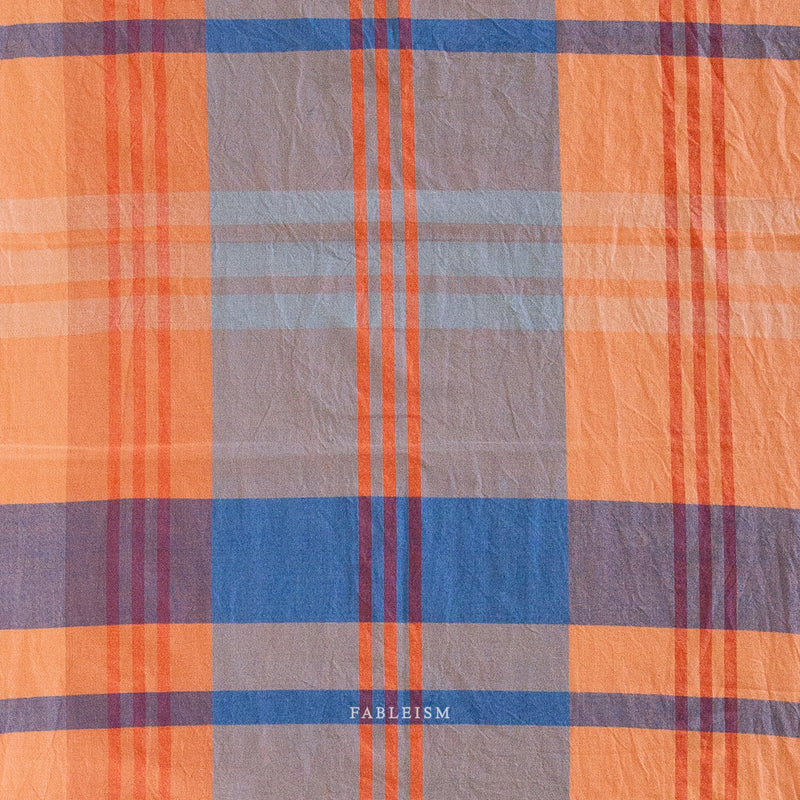 Plaid fabric with orange, blue, and gray colors 