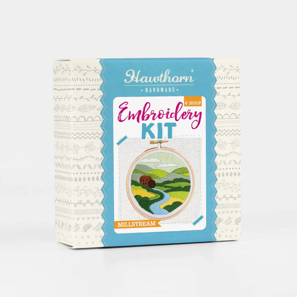Embroidery kit packaging with scenic design on a white background