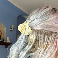 Garlic-shaped hair claw, clipped into blonde hair.