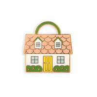 A needle minder shaped like a house with a pink roof, yellow door, and green shrubs on a white background