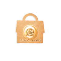 Gold magnetic pin on a house-shaped needleminder with "Sarah Hearts” embossed. 