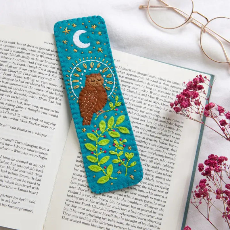 Embroidered bookmark with owl design on an open book with flowers