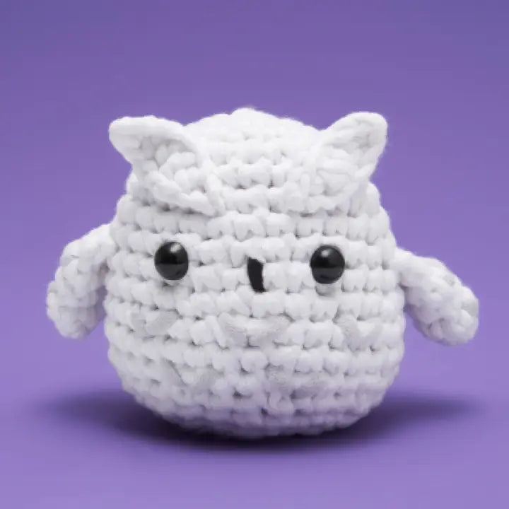 White crochet owl plush toy on a purple background