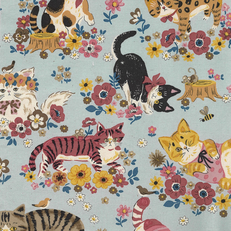 Fabric pattern with cats, flowers, and birds on a blue background