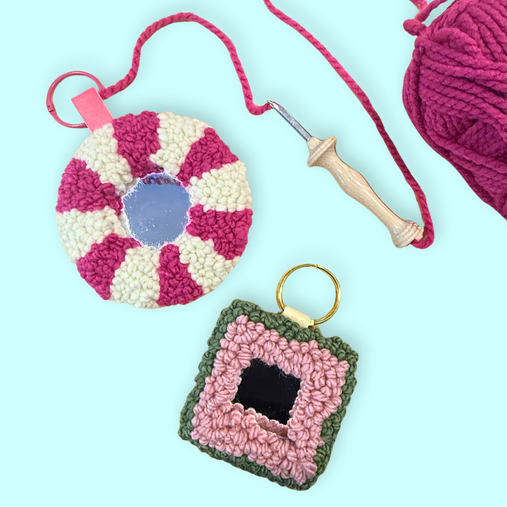 Two small mirrors with texturd yarn frames on a blue background