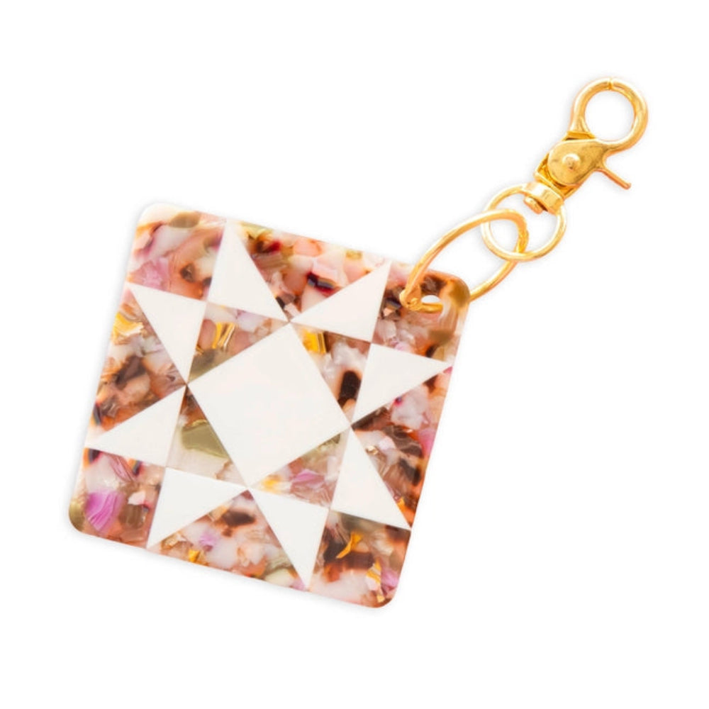  A multicolor  keychain with a quilting star pattern in white and a golden clasp against a white background