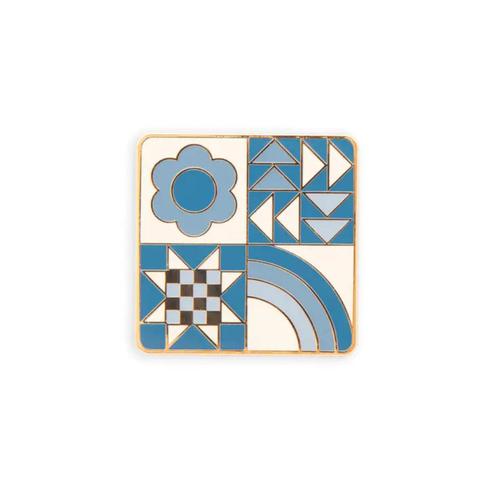 Square needle minder with different designs: blue flower, a quilting star, triangles, and a rainbow against a white background