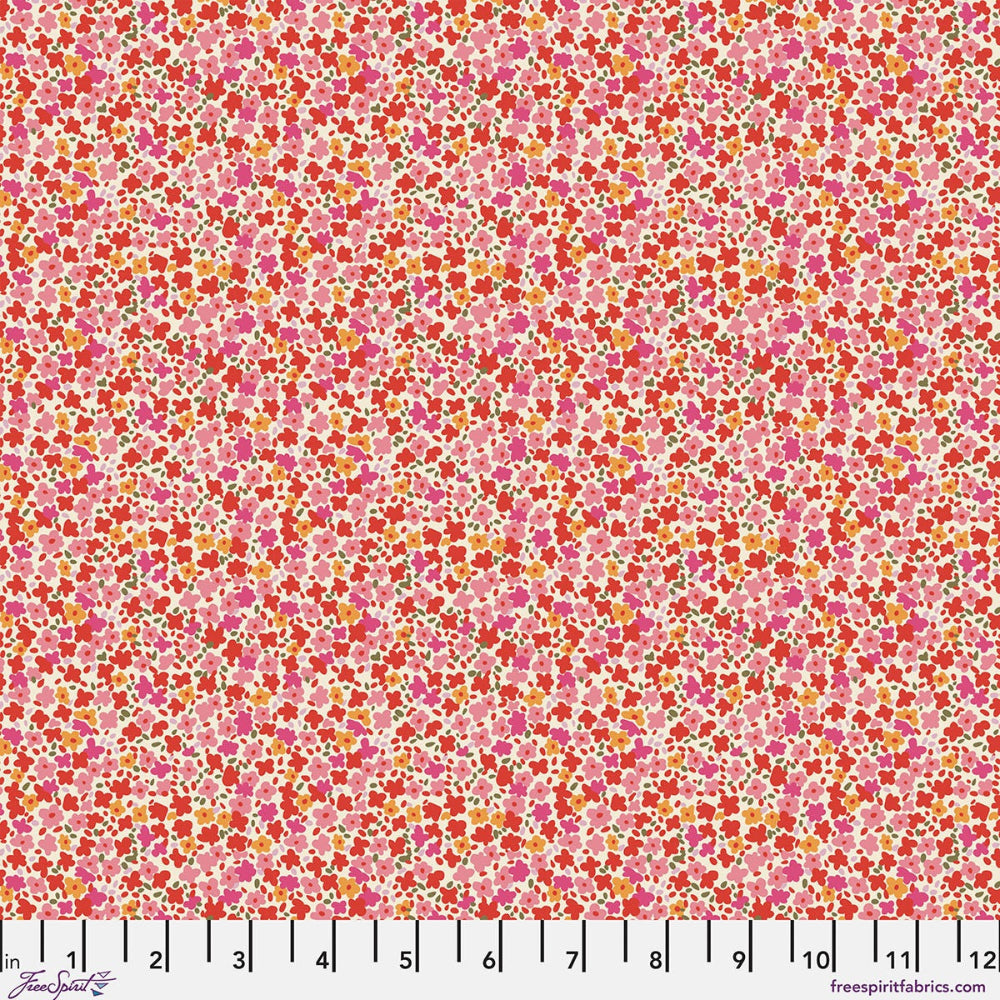A close-up of a fabric pattern featuring a dense, small-scale floral print in shades of pink, red, orange, and yellow on a light pink background, with a white ruler scale at the bottom indicating inches.