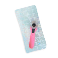 A holographic cutting mat with a pink rotary cutter design attached, set against a white background.