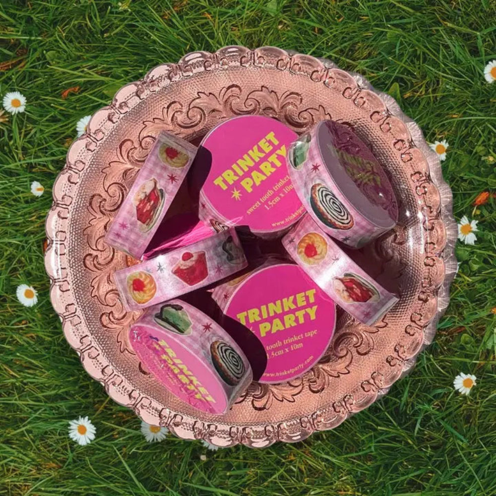 Decorative pink plate with 'Trinket Party' products on a grassy background
