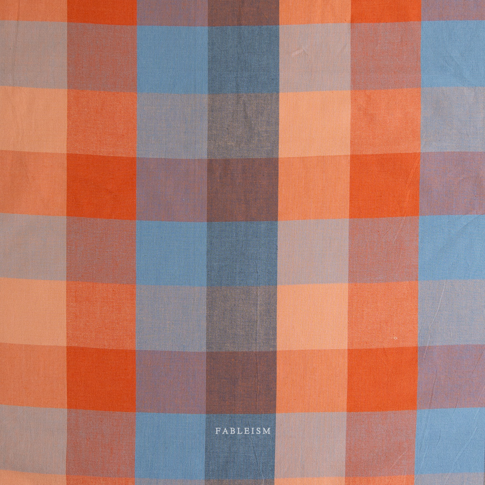 Plaid fabric pattern with orange, blue, and brown colors