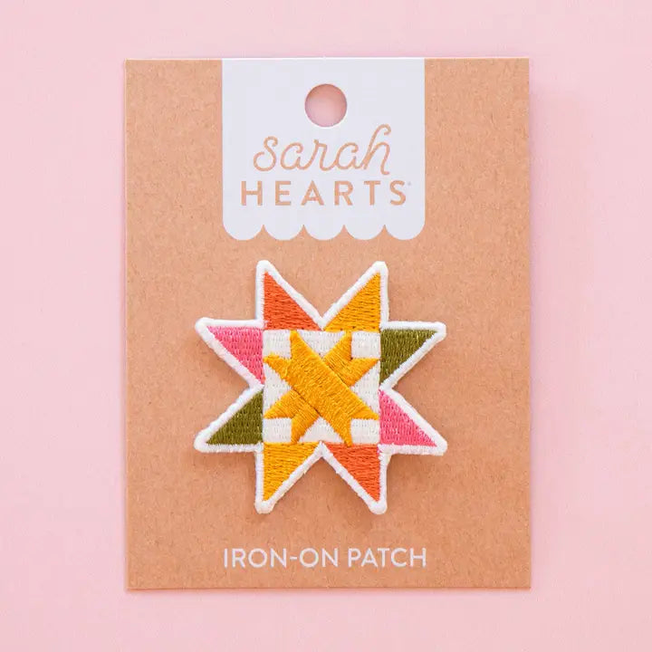 Colorful sawtooth quilt block iron-on patch on a 'Sarah Hearts' branded card with a pink background