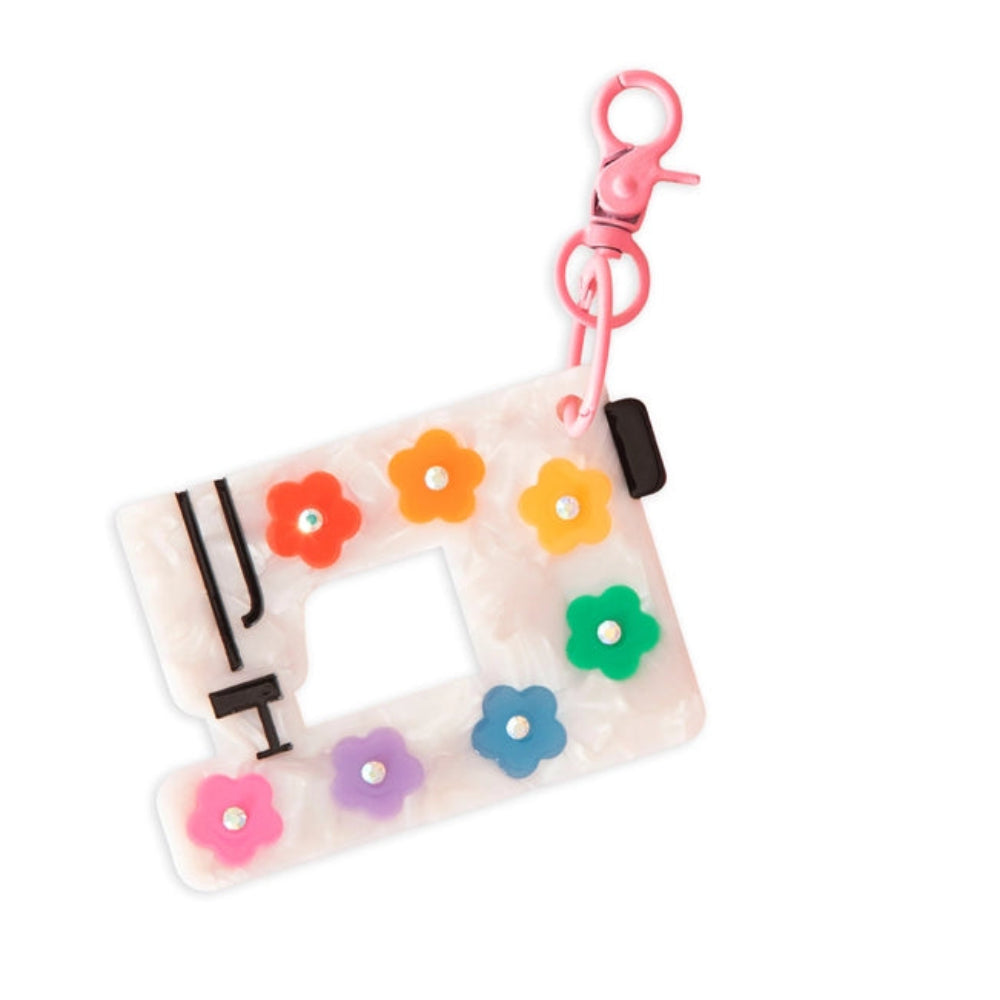 Colorful sewing machine keychain with flower decorations against a white background. 