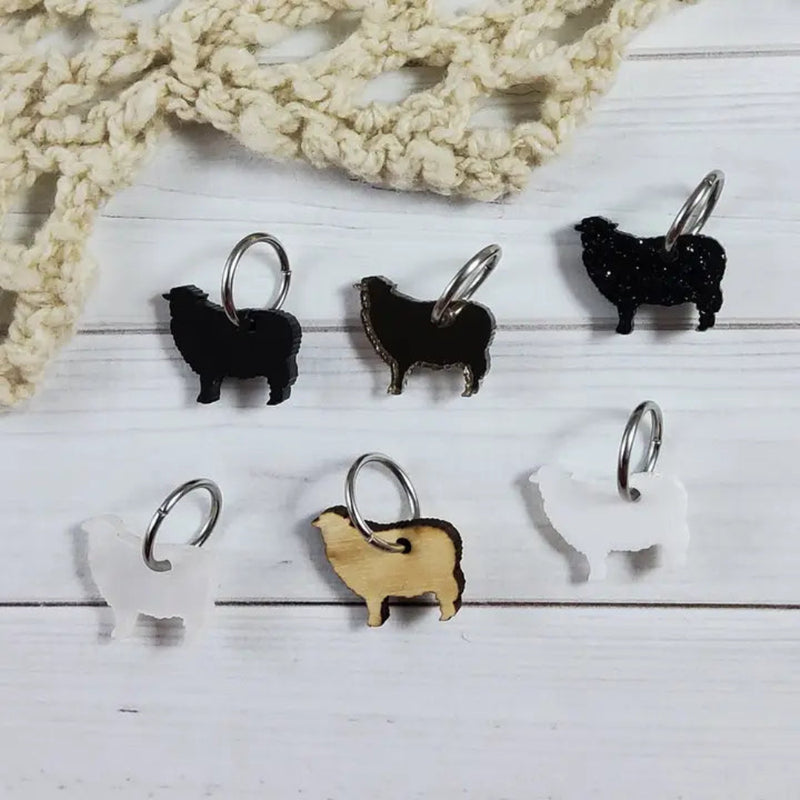 Set of sheep stitch markers on a wooden surface 