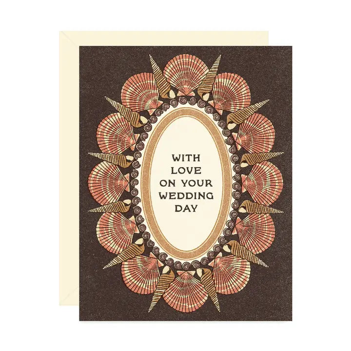A dark brown greeting card card featuring a frame of seashells surrounding the message “With love on your wedding day" on a white background.