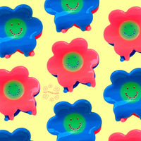 Colorful flower-shaped objects with smiley faces on a yellow background