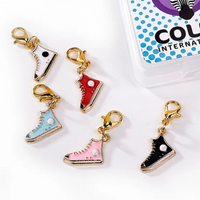 Enamel and metal sneaker-shaped stitch markers in assorted colors, with gold metal lobster clasps.
