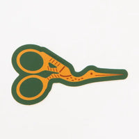 A sticker with an illustration of yellow stork scissors with a green background. 