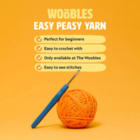 Orange yarn ball with a blue crochet hook on an orange background with 'Woobles' branding.
