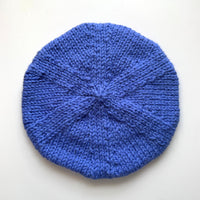 Blue knitted beret on a white background
